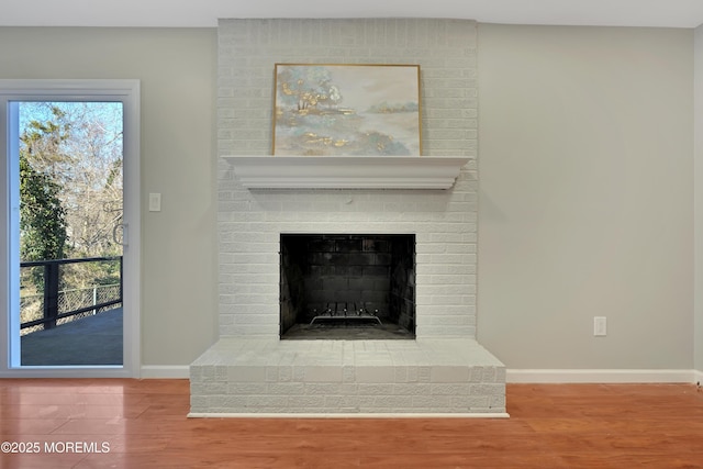 details with a brick fireplace, baseboards, and wood finished floors