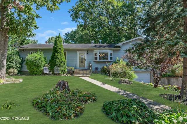 ranch-style house featuring a garage, a front yard, and fence