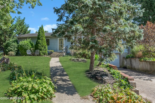 obstructed view of property featuring a garage, driveway, and a front lawn