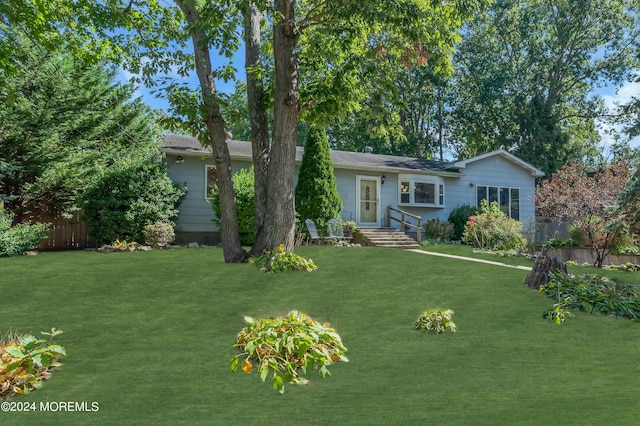 single story home with a front lawn and fence