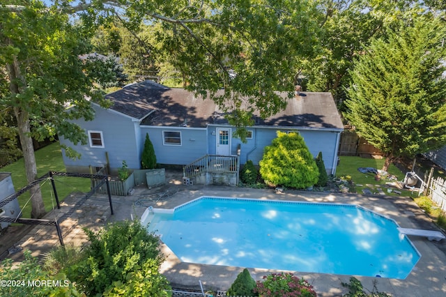 view of pool with a fenced in pool, fence, a diving board, and a lawn