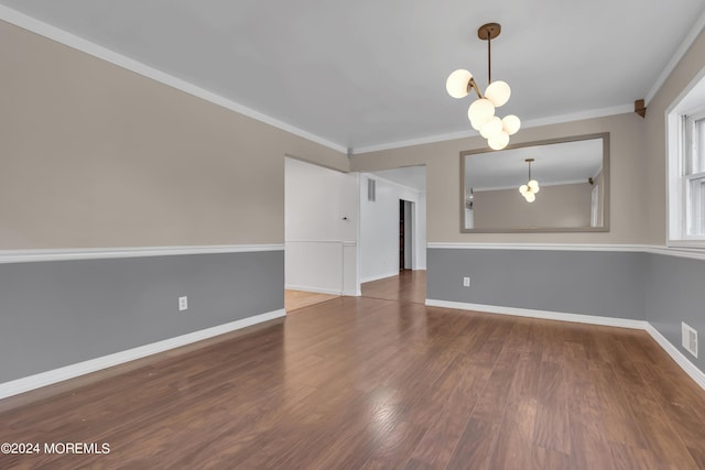 spare room featuring baseboards, crown molding, and wood finished floors