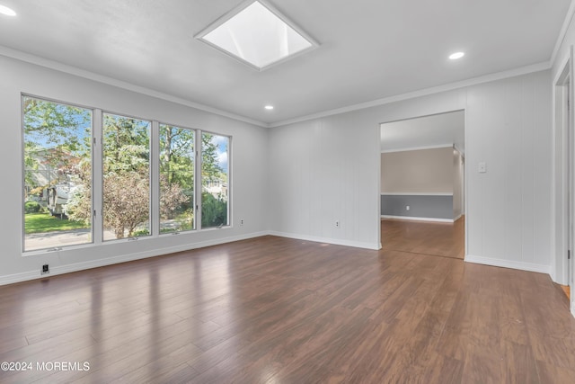 empty room with dark wood-type flooring, a skylight, recessed lighting, and crown molding