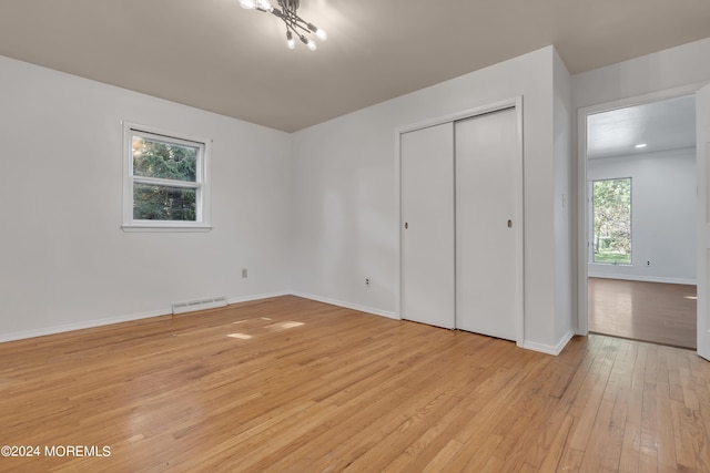 unfurnished bedroom with light wood-style flooring, a closet, visible vents, and baseboards