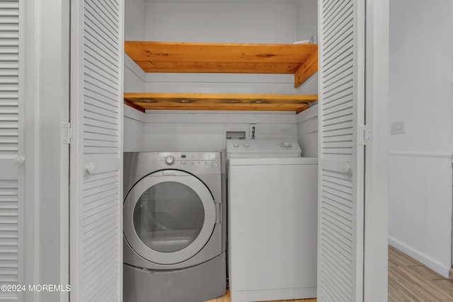 laundry room featuring light wood-type flooring, laundry area, wainscoting, and independent washer and dryer