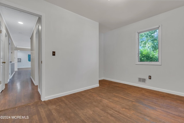 spare room featuring wood finished floors, visible vents, and baseboards