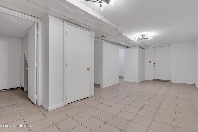 finished basement with visible vents and light tile patterned floors