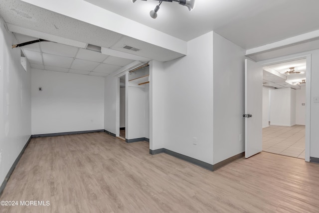 unfurnished room with light wood-type flooring, visible vents, and a drop ceiling