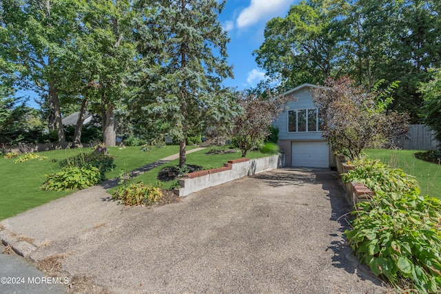 exterior space with a garage, concrete driveway, and a front yard