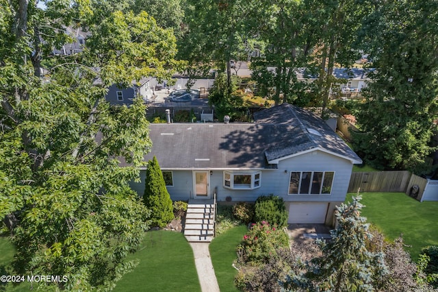 view of front of home featuring a garage, a front yard, fence, and driveway