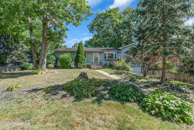 view of front of home featuring a garage, a front yard, and fence