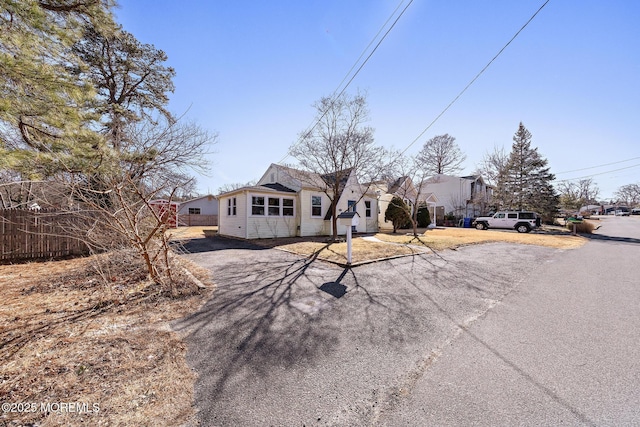 view of front facade featuring driveway and fence