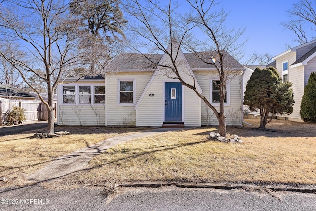 view of front of house with entry steps, fence, and a front yard