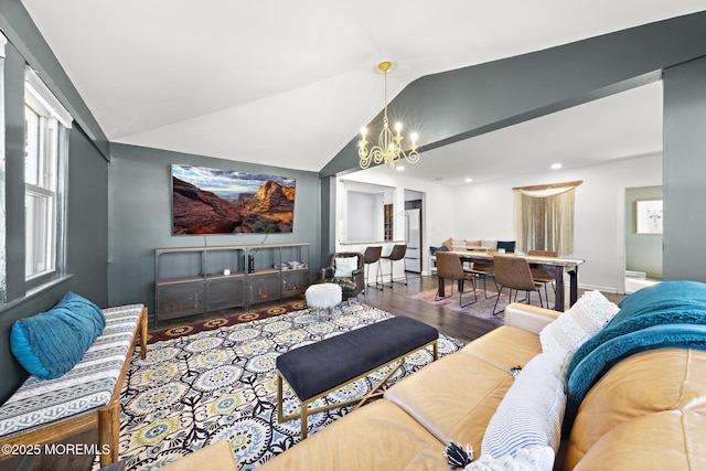 living area featuring lofted ceiling, wood finished floors, and a notable chandelier