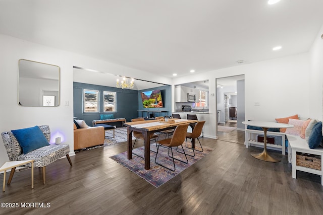 dining area with recessed lighting, baseboards, an inviting chandelier, and wood finished floors