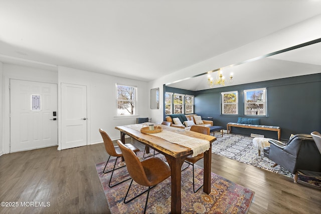 dining area with wood finished floors and an inviting chandelier