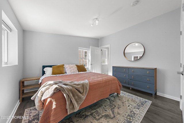 bedroom with dark wood finished floors and baseboards