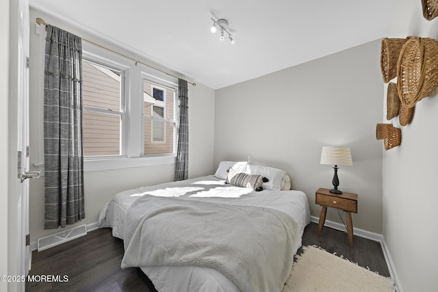 bedroom with wood finished floors, visible vents, and baseboards