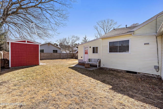 view of yard featuring a storage shed, fence, and an outbuilding