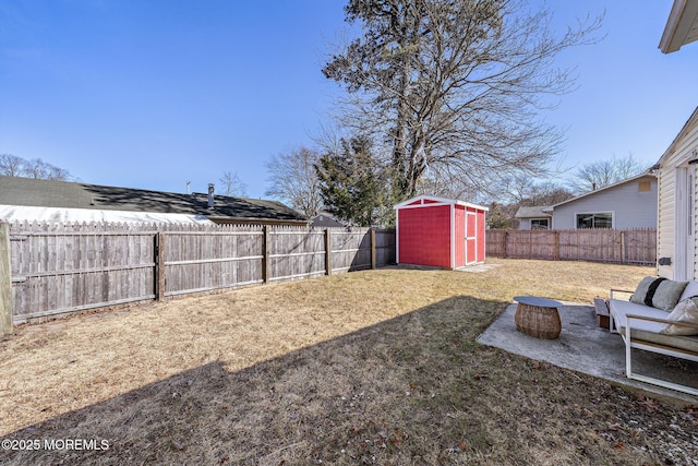 view of yard featuring a storage shed, a fenced backyard, a patio area, and an outdoor structure