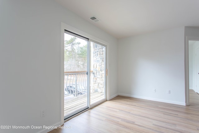 unfurnished room with light wood finished floors, visible vents, and baseboards