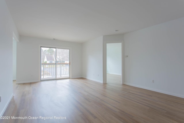 spare room with wood finished floors and baseboards