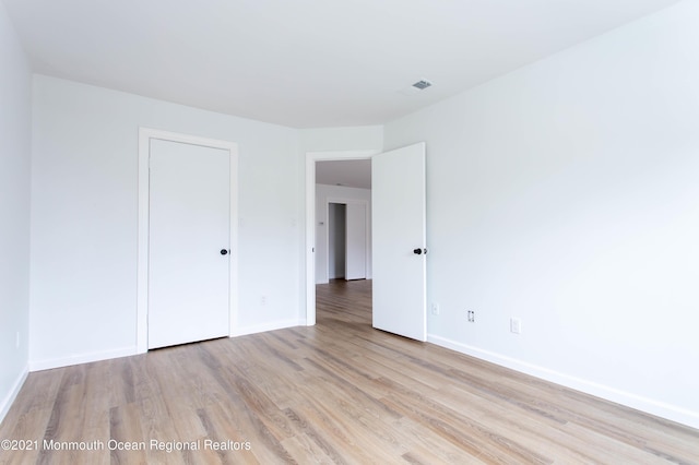 unfurnished bedroom with wood finished floors and baseboards