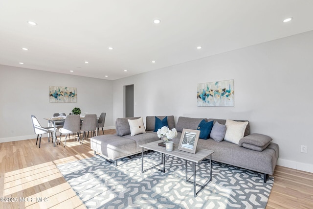 living area with baseboards, light wood-type flooring, and recessed lighting