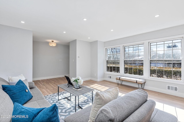 living area featuring light wood finished floors, baseboards, visible vents, and recessed lighting