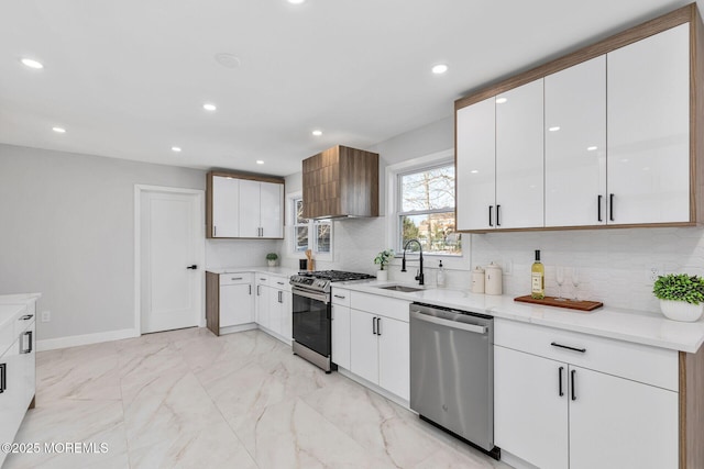 kitchen featuring tasteful backsplash, marble finish floor, stainless steel appliances, white cabinetry, and a sink