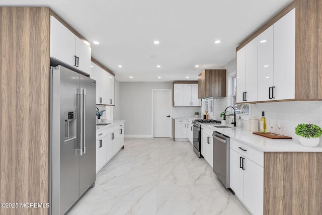 kitchen with tasteful backsplash, marble finish floor, stainless steel appliances, a sink, and recessed lighting