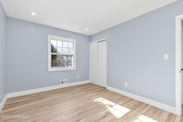 unfurnished bedroom featuring baseboards, visible vents, wood finished floors, and recessed lighting