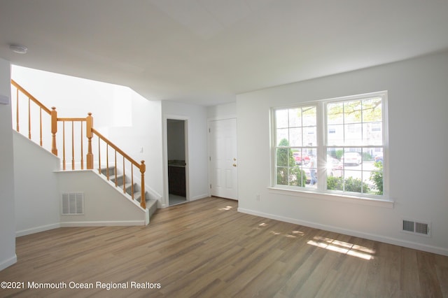 interior space with visible vents, stairway, baseboards, and wood finished floors