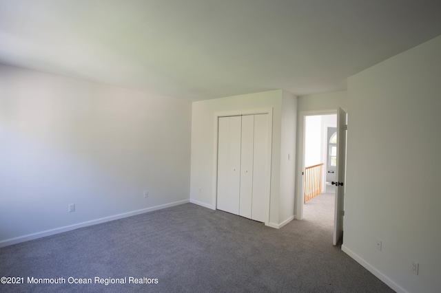 unfurnished bedroom featuring a closet, carpet flooring, and baseboards