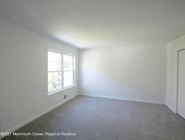 carpeted empty room with baseboards and visible vents