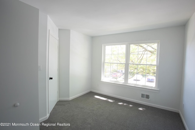 carpeted spare room with baseboards and visible vents