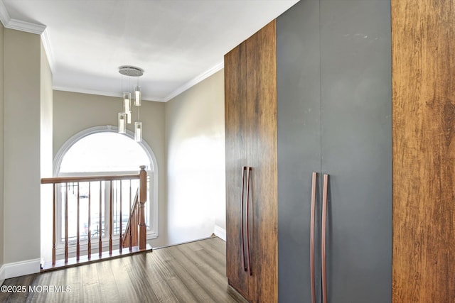 hallway with crown molding, baseboards, and wood finished floors