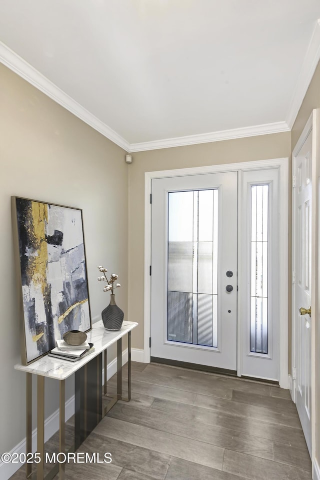 entryway featuring ornamental molding, wood finished floors, and baseboards