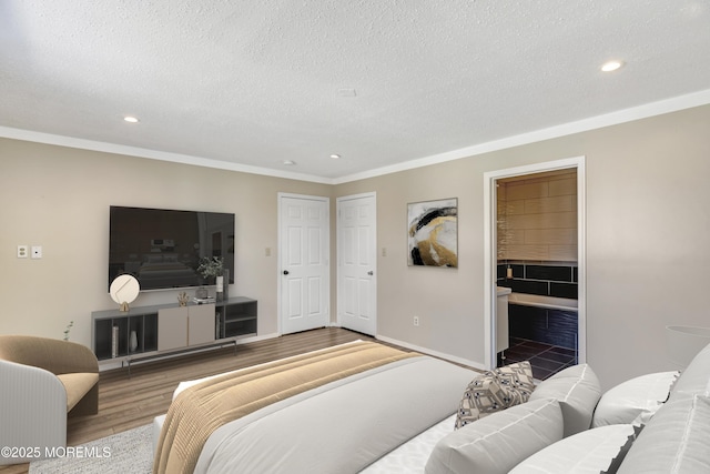 bedroom featuring recessed lighting, a textured ceiling, baseboards, and wood finished floors