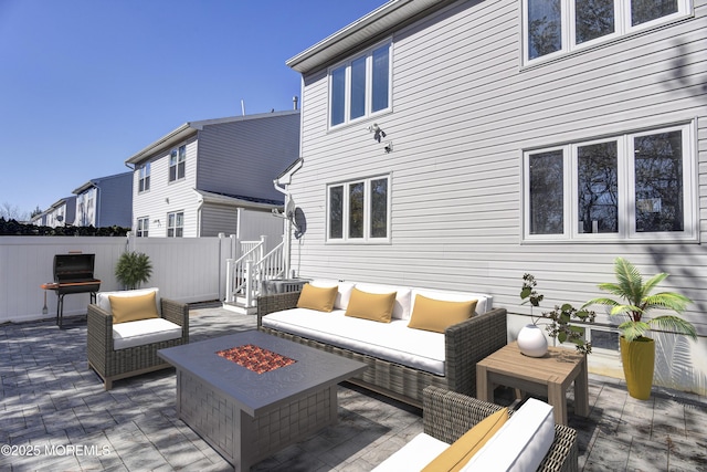 view of patio with an outdoor living space with a fire pit, fence, and grilling area