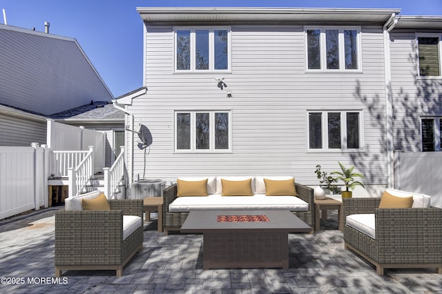 rear view of house with an outdoor hangout area, a patio area, and fence