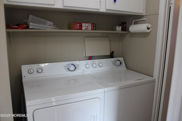 washroom with cabinet space and washing machine and clothes dryer