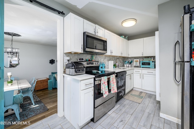 kitchen featuring appliances with stainless steel finishes, decorative backsplash, a sink, and light countertops