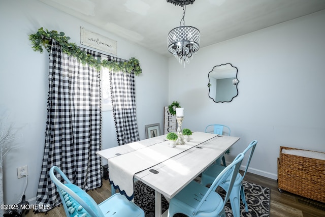 dining area featuring an inviting chandelier, baseboards, and wood finished floors