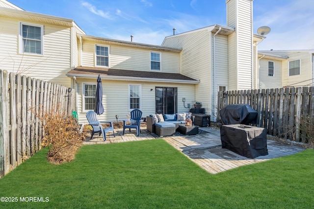 rear view of property with a fenced backyard, an outdoor living space, a yard, a chimney, and a patio area