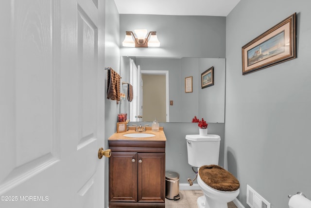 half bathroom featuring toilet, vanity, and visible vents