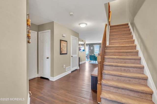 stairs with visible vents, baseboards, and wood finished floors