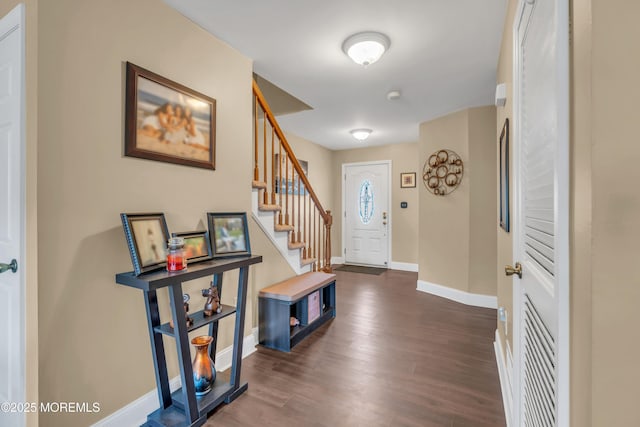 foyer entrance featuring baseboards, stairway, and dark wood finished floors