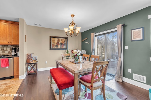 dining room featuring an inviting chandelier, visible vents, and dark wood finished floors