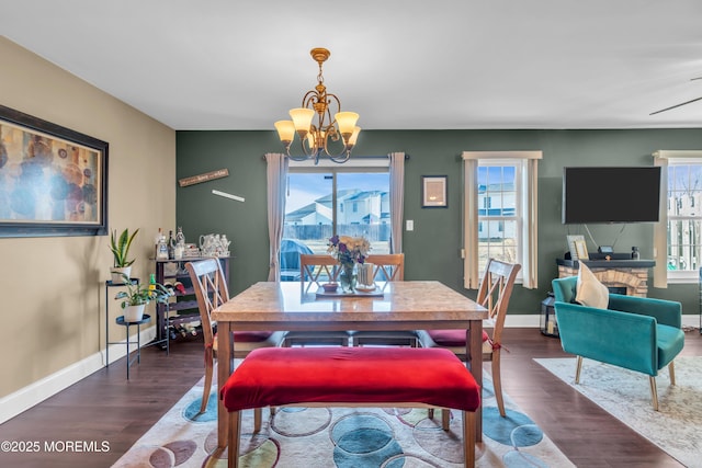 dining room with a chandelier, dark wood-style floors, and a wealth of natural light